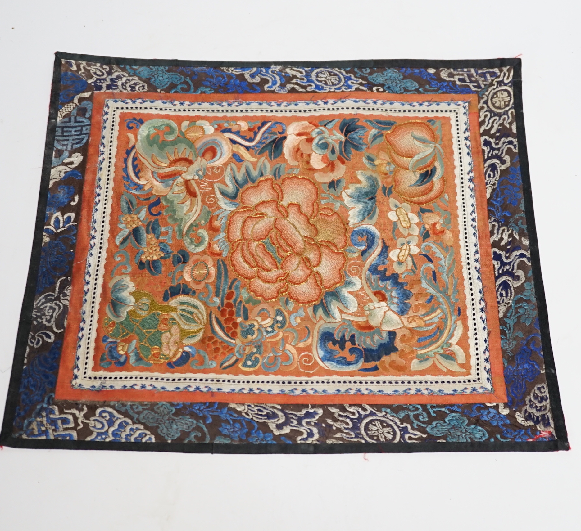 Six Chinese silk mats, embroidered with silk polychrome thread, all using mixed stitches including Beijing knot, five bordered with silk brocade, largest 43cm wide x 37cm high